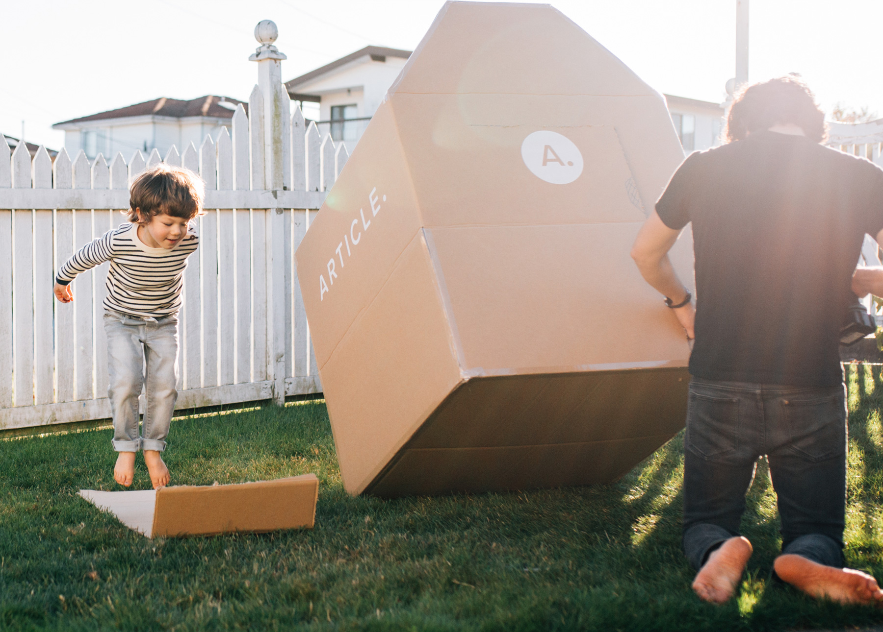 A father and son work together to create a cardboard box fort